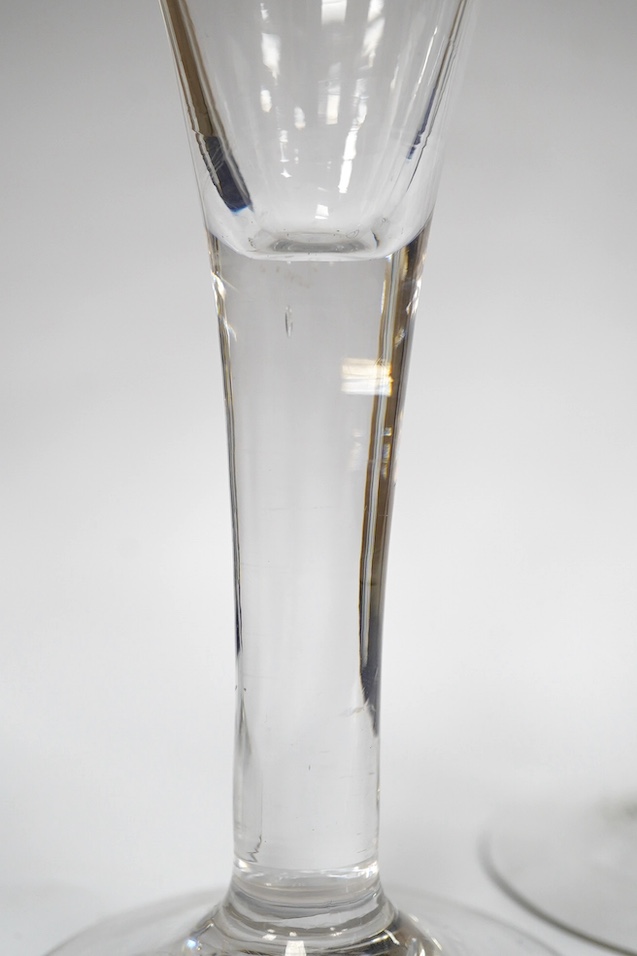 Two drawn trumpet wine glasses, late 18th century and a balustroid gin glass, c.1740, 12.4cm - 18.7cm high (3). Condition - the slender trumpet wine glass has some glue residue to the pontil mark but there is no evidence